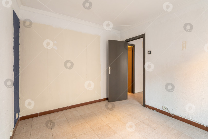Скачать Пустая просторная комната с дверью и грязными стенами в старой квартире до ремонта. фотосток Ozero