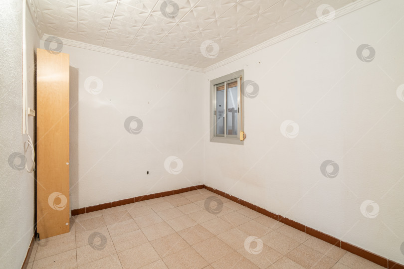 Скачать Пустая просторная комната с окном и грязными стенами в старой квартире до ремонта. фотосток Ozero