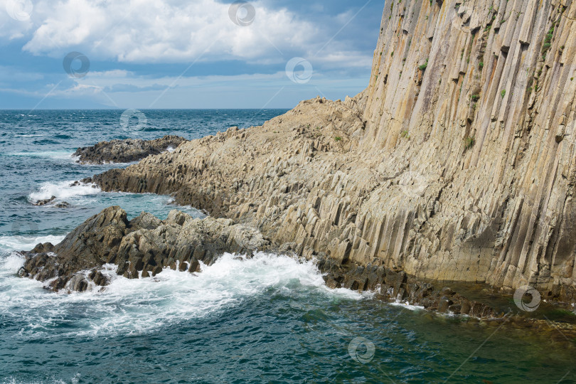 Скачать природный ландшафт с отвесной скалой, сложенной столбчатым базальтом на берегу моря фотосток Ozero