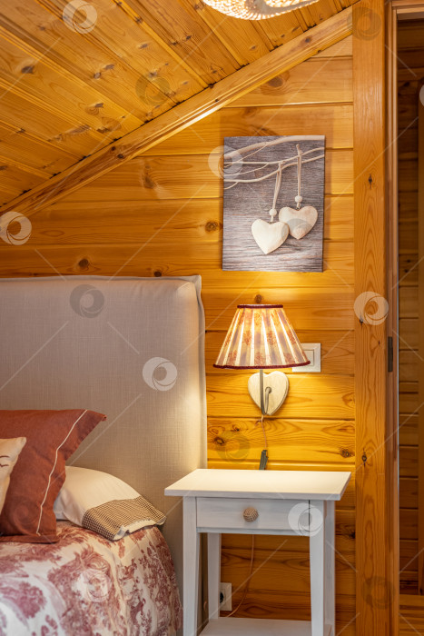 Скачать Классическая лампа над ночным столиком в спальне в деревянном интерьере комнаты. фотосток Ozero