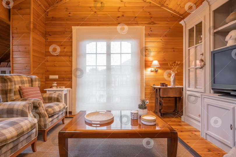 Скачать Уютный интерьер загородного дома в деревянном исполнении. Просторная гостиная со стульями, столом и большим шкафом фотосток Ozero