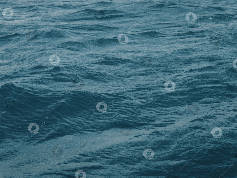 Скачать Темно-сине-зеленый цвет водной глади с волнами посреди бескрайней морской пучины. Бесконечная волнистая гладь голубой морской воды. Темно-синие волны в глубоком океане. Бушующие аквамариновые волны на поверхности воды. фотосток Ozero
