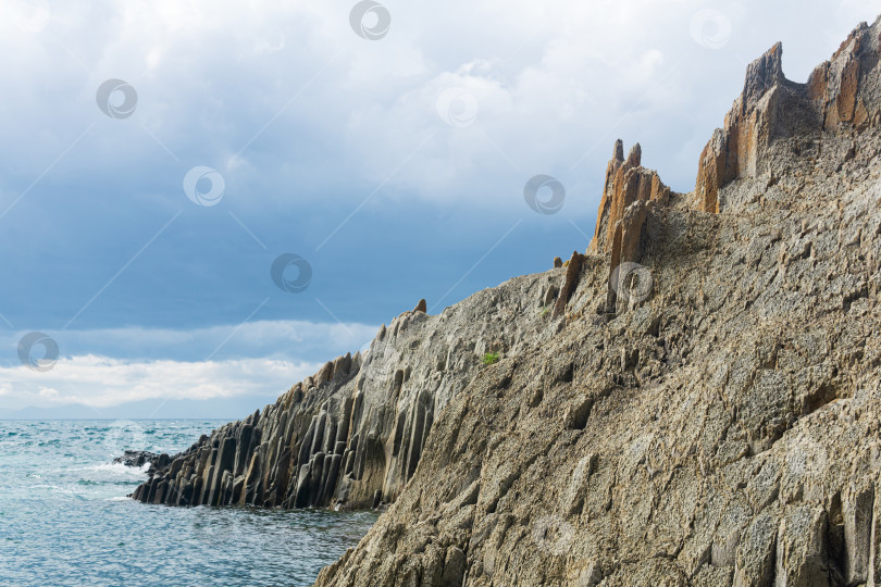 Скачать природный ландшафт с отвесной скалой сложенной столбчатым базальтом на берегу моря фотосток Ozero