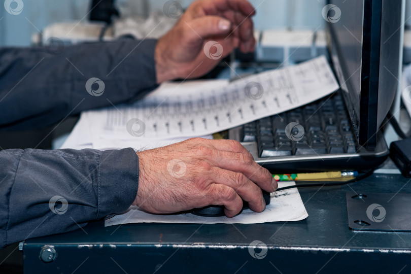 Скачать натруженные руки пожилого работника за компьютером, управляющим производственным процессом фотосток Ozero