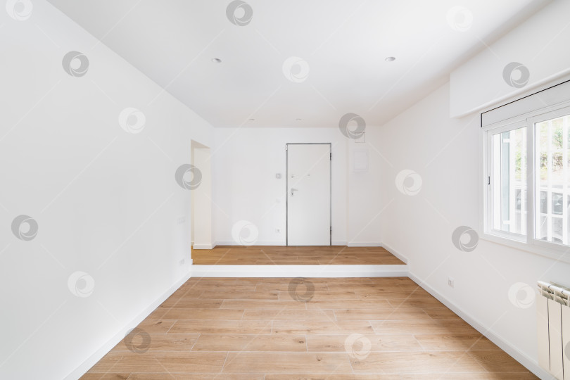 Скачать Пустая комната после ремонта с окном, белыми стенами и деревянным полом в новой квартире фотосток Ozero