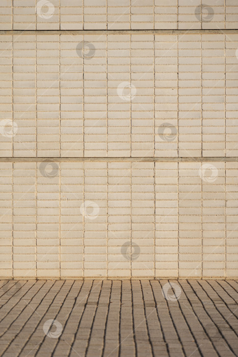 Скачать Текстура каменной стены с бежевыми кирпичами на улице утром. Узор декоративной стены в качестве фона фотосток Ozero