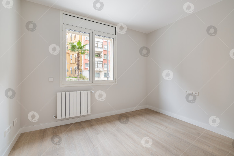 Скачать Пустая белая комната с отоплением и окном с видом на город. Интерьер современной квартиры. фотосток Ozero