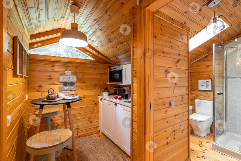 Скачать Компактная кухня с небольшой ванной комнатой в деревянном доме. Концепция деревенской жизни. Перевод: счастье здесь, хорошая жизнь прямо здесь. фотосток Ozero