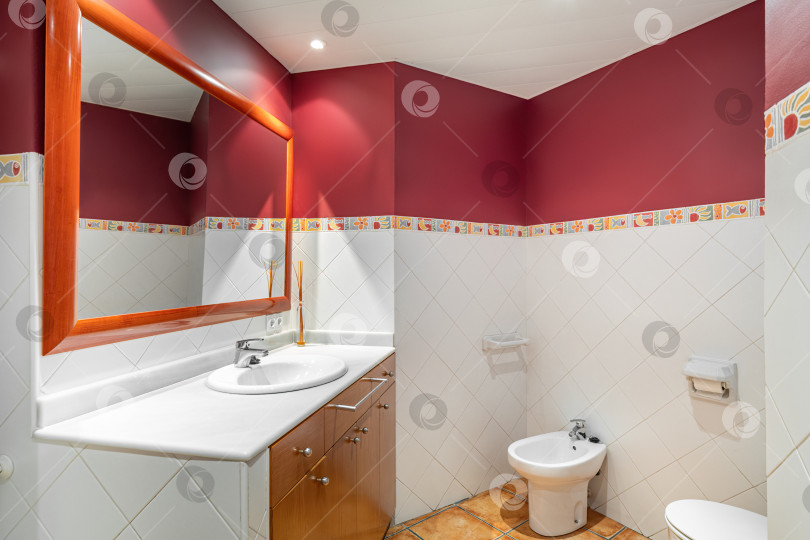 Скачать Ванная комната оформлена в красно-белых тонах с зеркалом, биде, туалетом. Чистая и пустая ванная комната фотосток Ozero