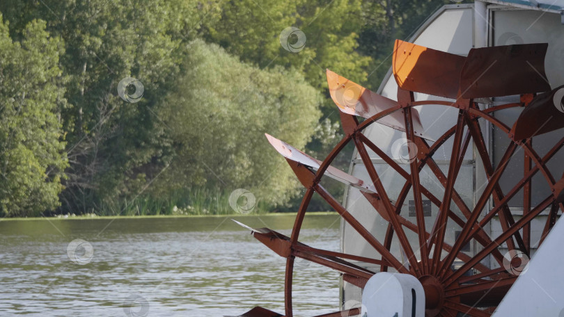 Скачать Красное гребное колесо речного катера на реке с деревьями фотосток Ozero