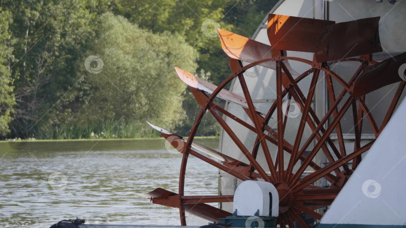 Скачать Красное гребное колесо речного катера на реке с деревьями фотосток Ozero