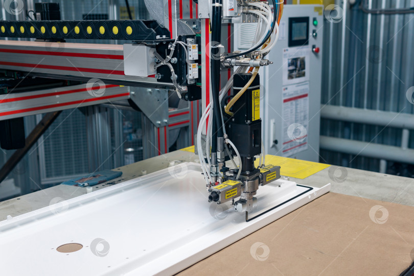 Скачать промышленная роботизированная машина-дозатор наносит отверждающийся герметик на металлическую дверную заготовку фотосток Ozero