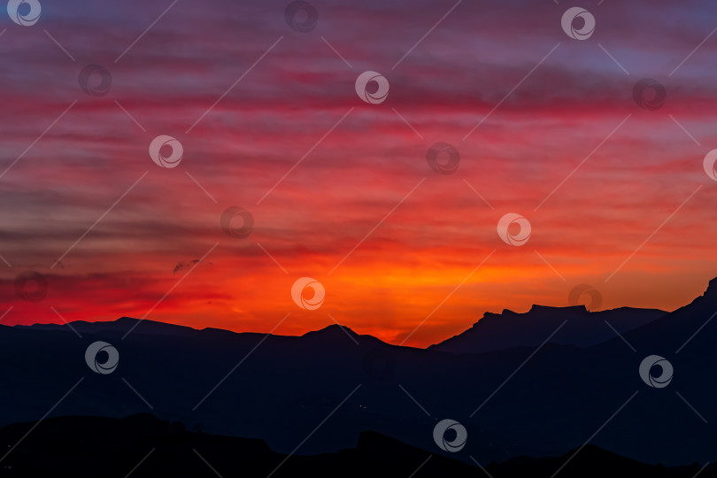 Скачать естественный фон - ярко-алое закатное небо над силуэтами горных вершин фотосток Ozero