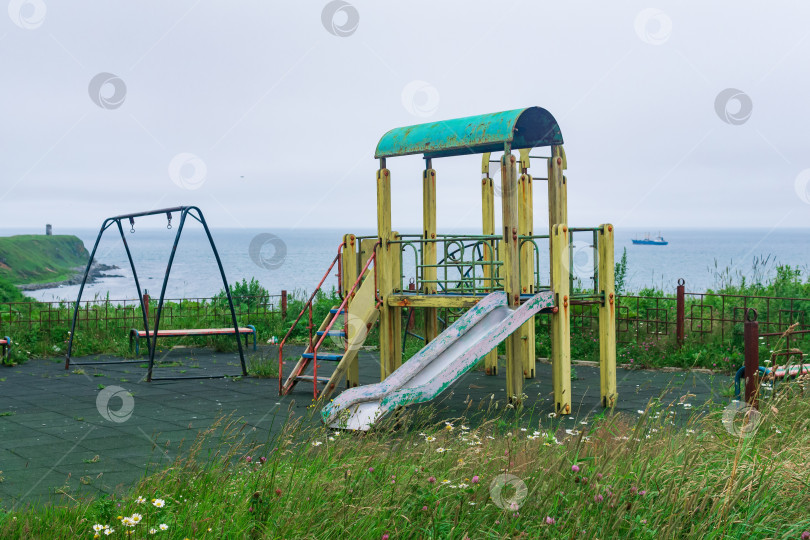 Скачать старая игровая площадка на острове у моря фотосток Ozero