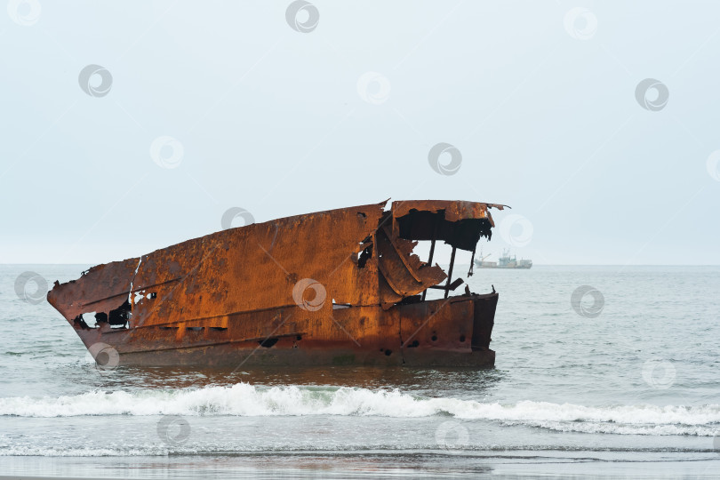 Скачать ржавое кораблекрушение на фоне туманного морского пейзажа с кораблем вдалеке фотосток Ozero