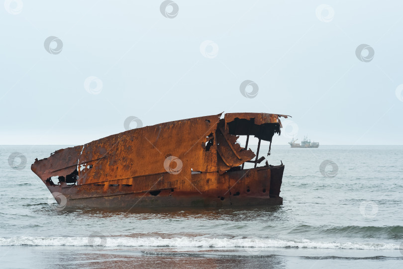 Скачать ржавое кораблекрушение на фоне туманного морского пейзажа с кораблем вдалеке фотосток Ozero