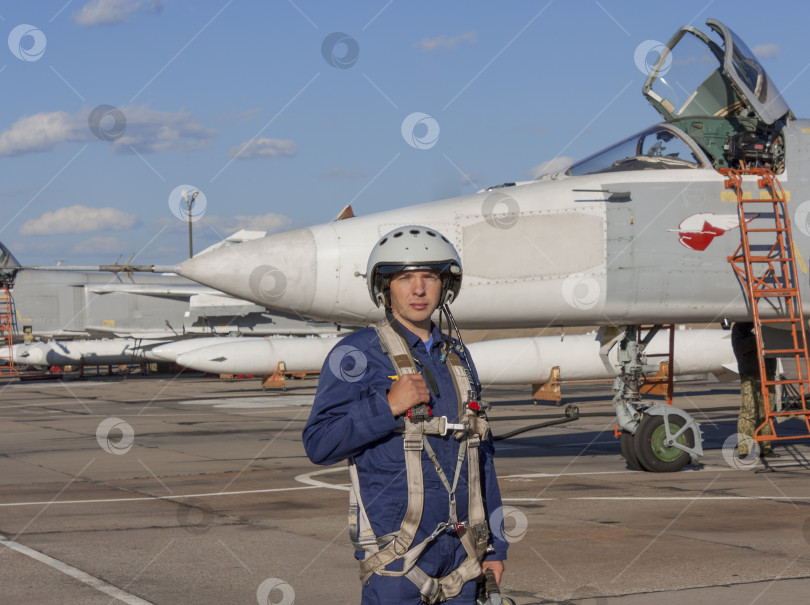 Скачать Военный летчик в шлеме стоит возле реактивного самолета фотосток Ozero