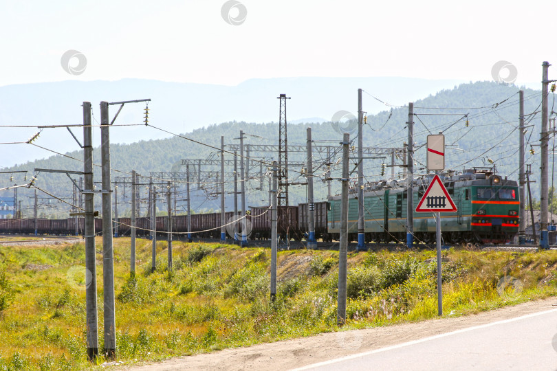 Скачать Большой зеленый электровоз с вагонами, идущими по железной дороге фотосток Ozero