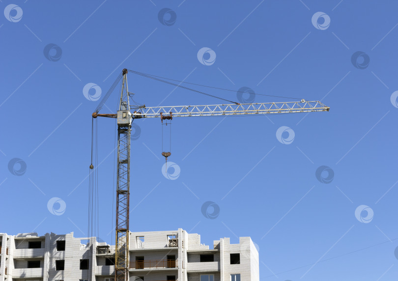 Скачать Промышленный пейзаж, строительный кран на фоне голубого неба фотосток Ozero