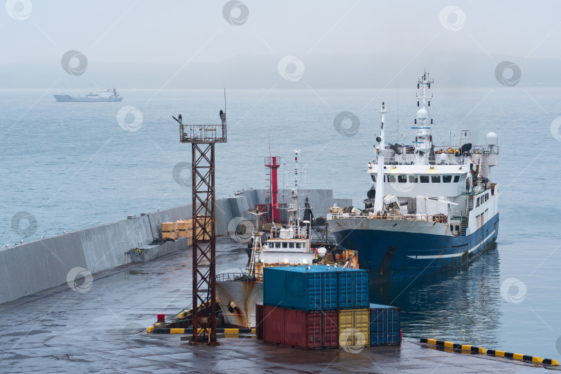 Скачать рыбацкая лодка у причала в гавани на берегу облачного моря фотосток Ozero