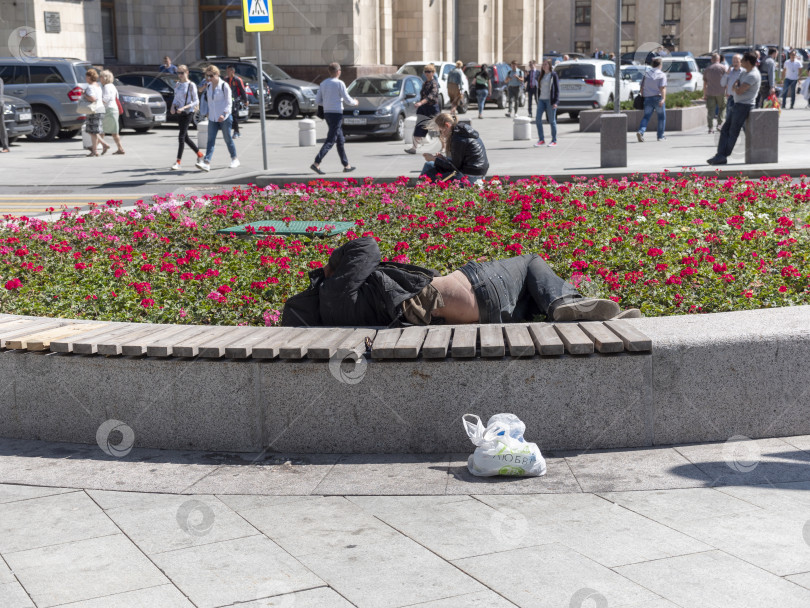 Скачать Москва, Россия - 28 августа 2021 года: бездомный нищий спит на скамейке фотосток Ozero