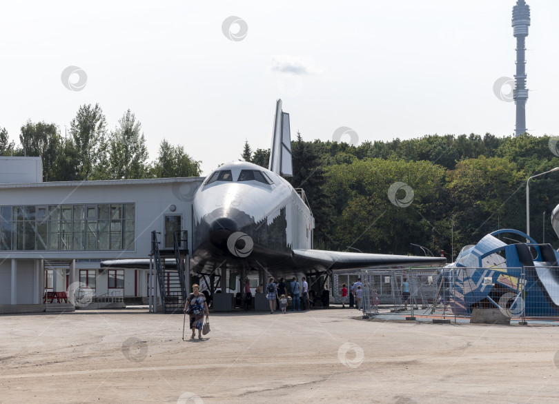 Скачать МОСКВА, РОССИЯ - 23 апреля 2019 года: Ракета-носитель "Восток" в павильоне "Космос" на ВДНХ. Гуляющие москвичи и туристы фотосток Ozero