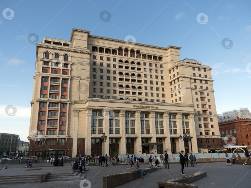 Скачать МОСКВА - 21 мая: Здание отеля Four Seasons Hotel Moscow и прогуливающиеся люди 21 мая 2019 года на Манежной площади в Москве фотосток Ozero