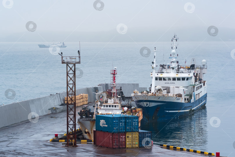 Скачать рыбацкая лодка у причала в гавани на берегу облачного моря фотосток Ozero