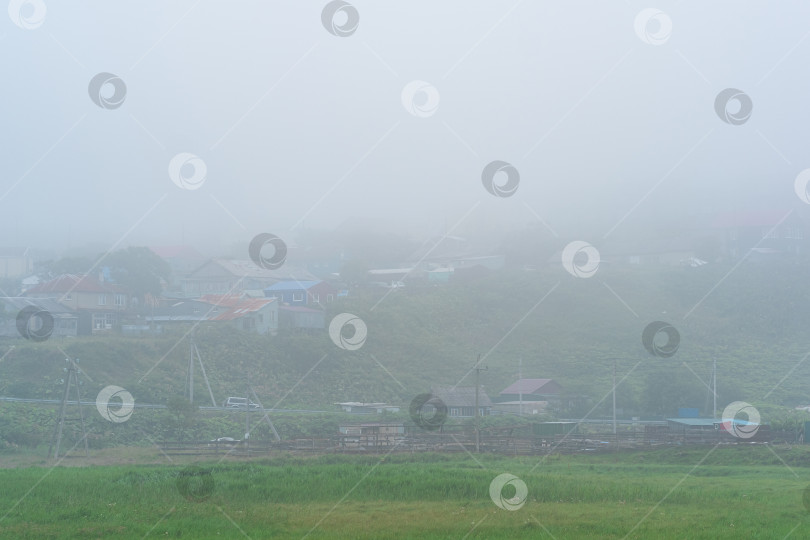 Скачать сельский пейзаж с домами и амбарами в густом тумане фотосток Ozero