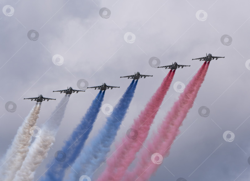 Скачать МОСКВА, РОССИЯ - 7 мая 2021 года: Авиапарад в Москве. Группа российских истребителей Су-25 с нарисованным российским флагом в небе на параде Победы во Второй мировой войне в Москве, Россия фотосток Ozero