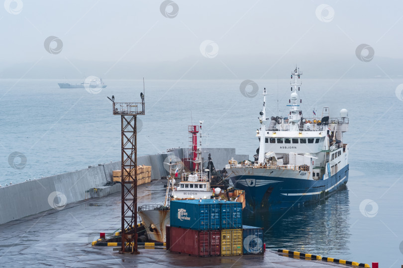 Скачать рыбацкая лодка у причала в гавани на берегу облачного моря фотосток Ozero