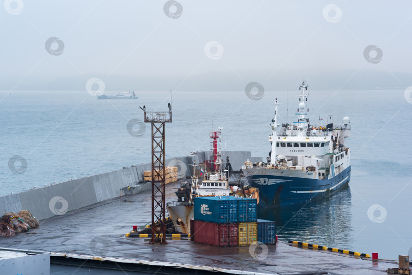 Скачать рыбацкая лодка у причала в гавани на берегу облачного моря фотосток Ozero