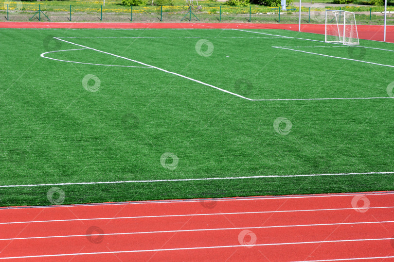 Скачать Футбольное зеленое поле с искусственной травой с белыми линиями фотосток Ozero