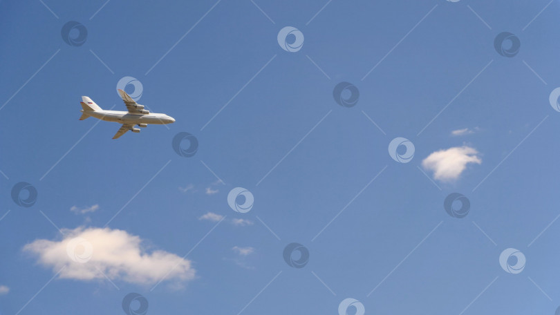 Скачать Военно-транспортный самолет Ан-124 летит в голубом небе фотосток Ozero