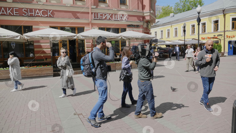 Скачать МОСКВА - 7 июня: Съемочная группа берет интервью у продавца мороженого 7 июня 2017 года в Москве, Россия. фотосток Ozero