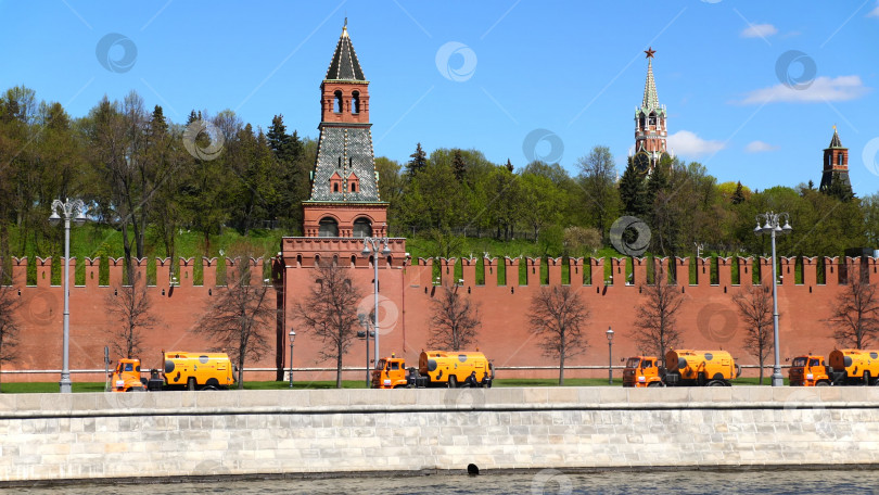 Скачать Москва, Российская Федерация. Вдоль стены Московского Кремля ходят оранжевые подметальщики. фотосток Ozero