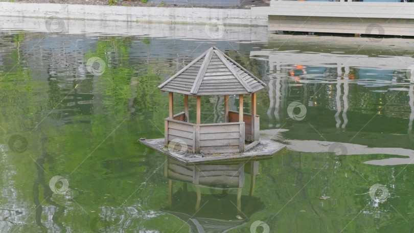 Скачать Деревянный утиный домик на пруду в сельской местности. фотосток Ozero