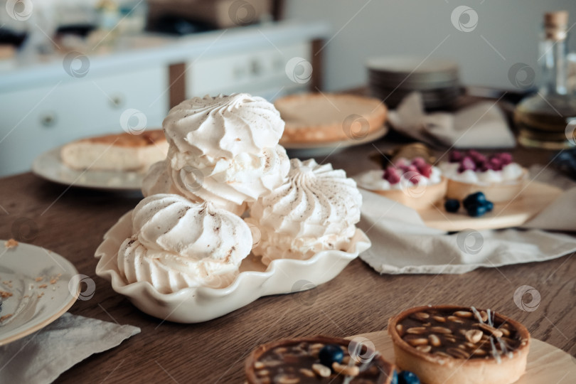 Скачать Белый воздушный торт с безе на праздничном столе, на кухне. фотосток Ozero