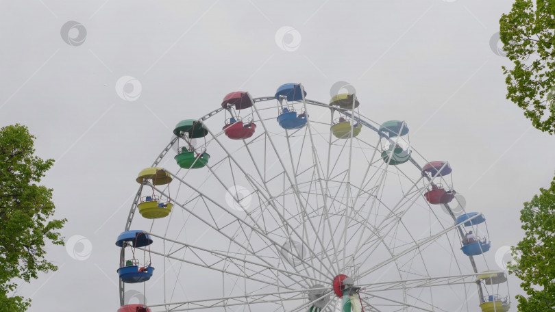 Скачать Вид снизу на колесо обозрения на фоне голубого неба. фотосток Ozero