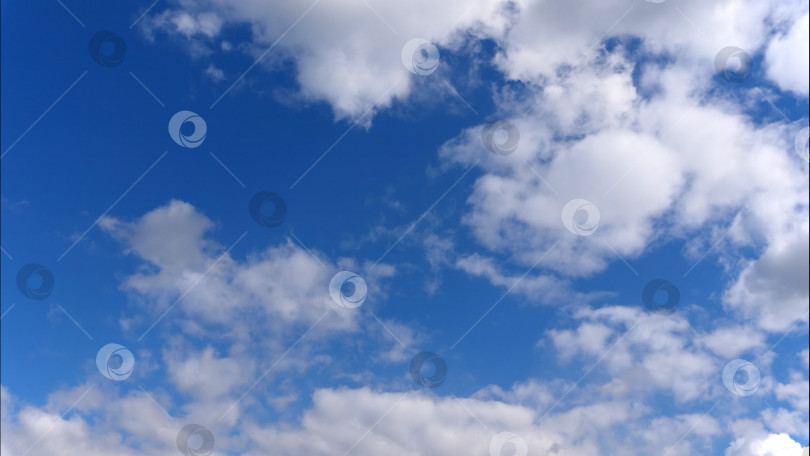 Скачать Замедленные пушистые облака плывут по голубому небу. фотосток Ozero