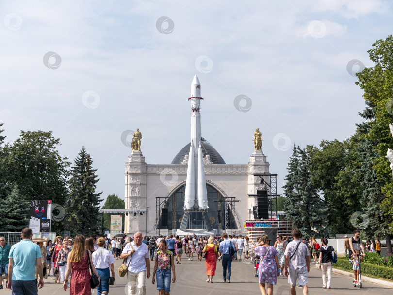 Скачать МОСКВА, РОССИЯ - 23 апреля 2019 года: Ракета-носитель "Восток" в павильоне "Космос" на ВДНХ. Гуляющие москвичи и туристы фотосток Ozero