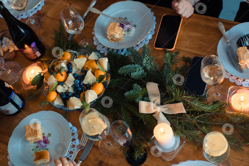 Скачать Рождественский ужин с мандаринами, свечами и еловыми ветками для украшения фотосток Ozero