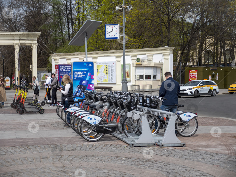 Скачать МОСКВА, РОССИЯ - 27 мая 2022 года: прокат велосипедов банка ВТБ. Пункт проката общественного транспорта рядом с парком Сокольники. Множество припаркованных велосипедов с логотипом банка фотосток Ozero
