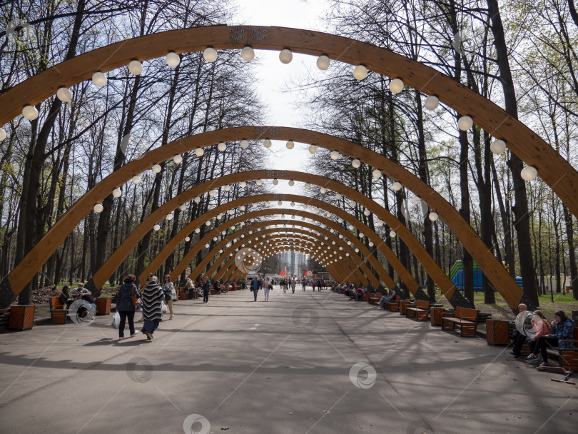 Скачать МОСКВА, РОССИЯ - 7 мая 2022 года, парк Сокольники, солнечный осенний день, деревянная арка фотосток Ozero