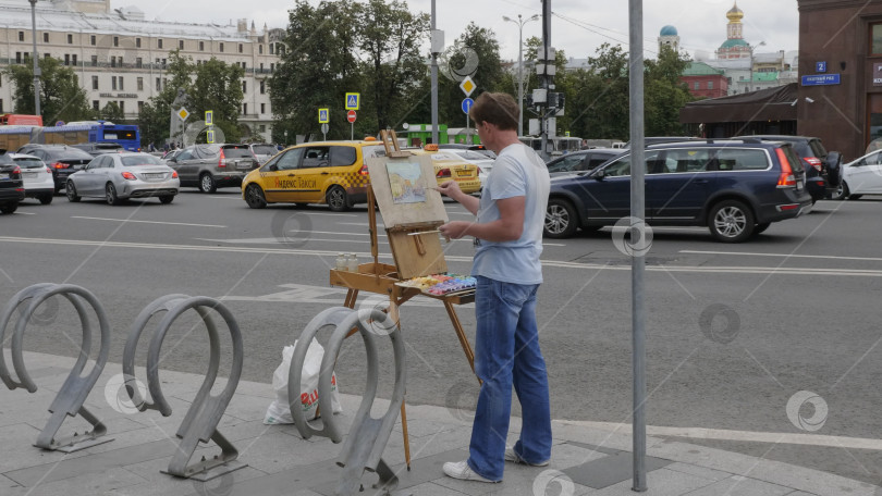 Скачать МОСКВА - 26 августа: Уличный художник рисует городской пейзаж 26 августа 2017 года в Москве, Россия. фотосток Ozero
