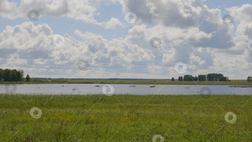 Скачать Вид на красивое озеро посреди поля. фотосток Ozero