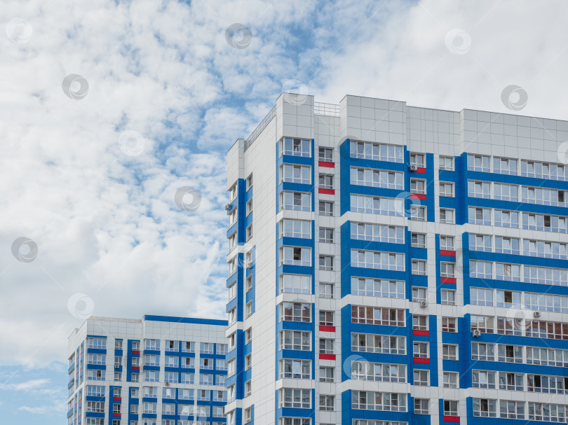 Скачать Современные красивые новые высотные жилые здания. Цветная стена на фоне голубого неба. Пространство для копирования. фотосток Ozero