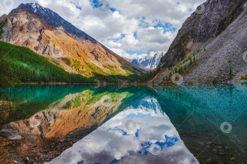 Скачать Живописное горное озеро в драматический день, Алтай. Прекрасное отражение гор, неба и белых облаков. фотосток Ozero