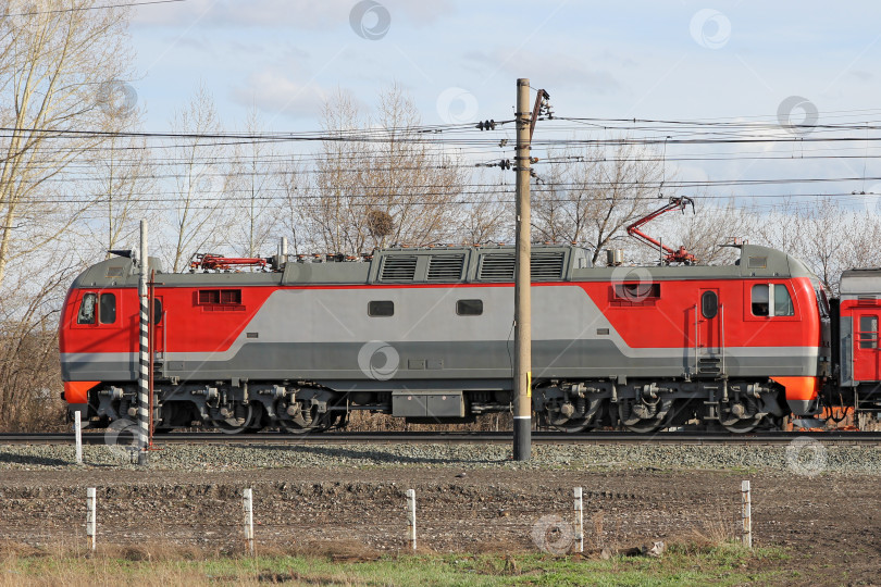 Скачать Красный локомотив на электричестве едет по железной дороге. фотосток Ozero