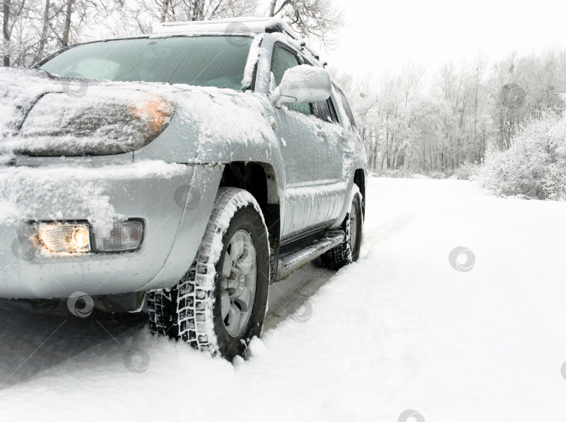 Скачать Заснеженная зимняя дорога за неузнаваемым автомобилем фотосток Ozero